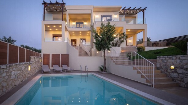 A modern two-story house with a swimming pool, outdoor seating, and a staircase leading to the upper floor.