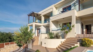 A modern two-story house with a swimming pool, outdoor stairs, and a pergola.