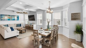 A modern living room with a dining area, white walls, wooden flooring, and a ceiling fan. - ☀️2 Masters~2 Golf Carts Included~6 Bikes~Pools~Last Call at NatureWalk 30A (Santa Rosa Beach)