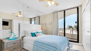 A bedroom with a bed, nightstands, a ceiling fan, a TV, and a balcony with a view. - Gulf Views~Beachfront Pool~Walk2Beach~2BR East Pass 209 (Destin)