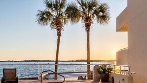 A pool area with a hot tub, palm trees, and a view of the water. - Gulf Views~Beachfront Pool~Walk2Beach~2BR East Pass 209 (Destin)