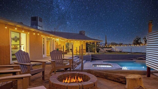 An outdoor patio with Adirondack chairs, a fire pit, and a pool. - Hot Tub, Pool, Firepit, Bball, Foosball, Hammocks (Yucca Valley)