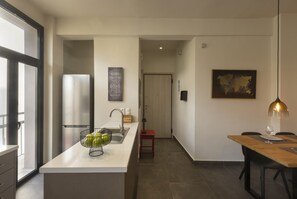 Une cuisine moderne dotée d’un îlot central, d’un réfrigérateur et d’un coin repas avec une table et des chaises.