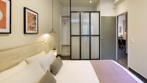 Een hotelkamer met een groot bed, een kledingkast en een bureau.