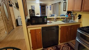 A compact kitchen with a microwave, sink, stove, and dishwasher.