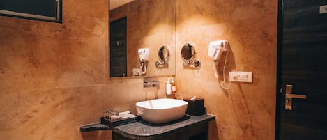 A modern bathroom with a large sink, mirrors, and a hairdryer.
