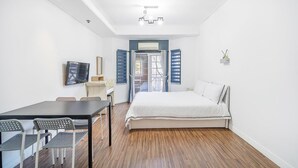 Une chambre à coucher avec un lit, une télévision, un bureau et des chaises.