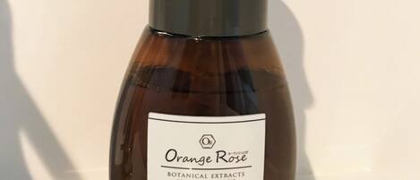 A bottle of Orange Rose hand and face soap with a pump dispenser.
