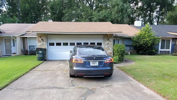 A residential garage with a car parked in front.