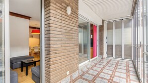 Ein modernes Interieur mit Backsteinwand, Glastür, strukturiertem Boden und einer Sitzecke mit Tisch und Stühlen.