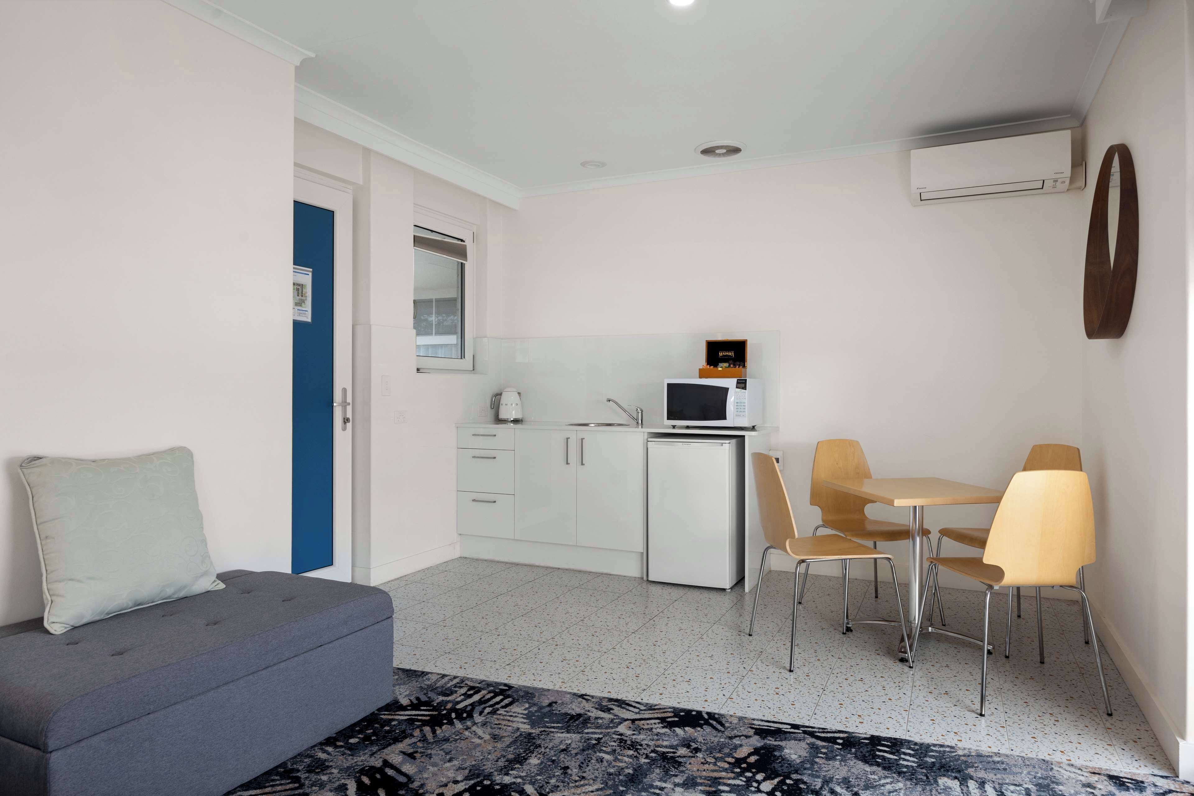 A compact living space with a kitchenette, a sofa, and a dining area.