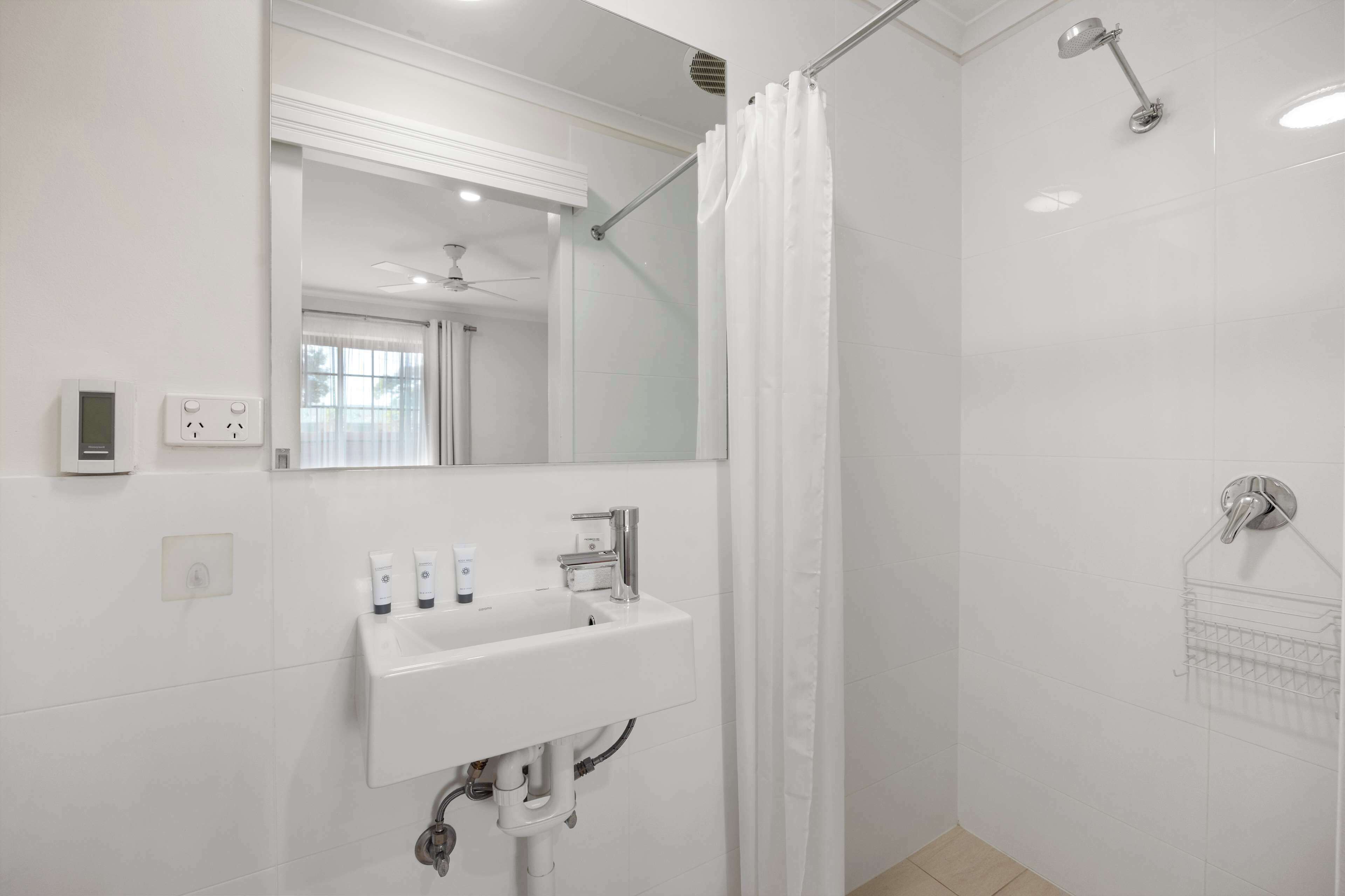 Ein modernes Badezimmer mit Waschbecken, Spiegel und Dusche.