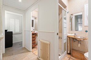Une salle de bain avec douche, lavabo et toilettes.