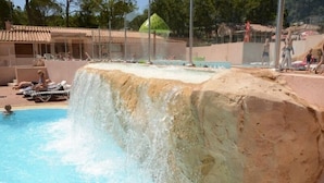 Una piscina al aire libre de temporada, sillones reclinables de piscina