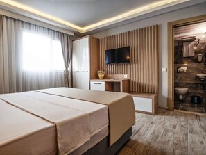 A modern hotel room with a large bed, a desk, a TV, and a bathroom visible through an open door. - Hotel Bleu Nuit Bodrum (Bodrum)