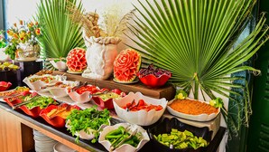 Een buffet met diverse gerechten en een decoratieve palm.