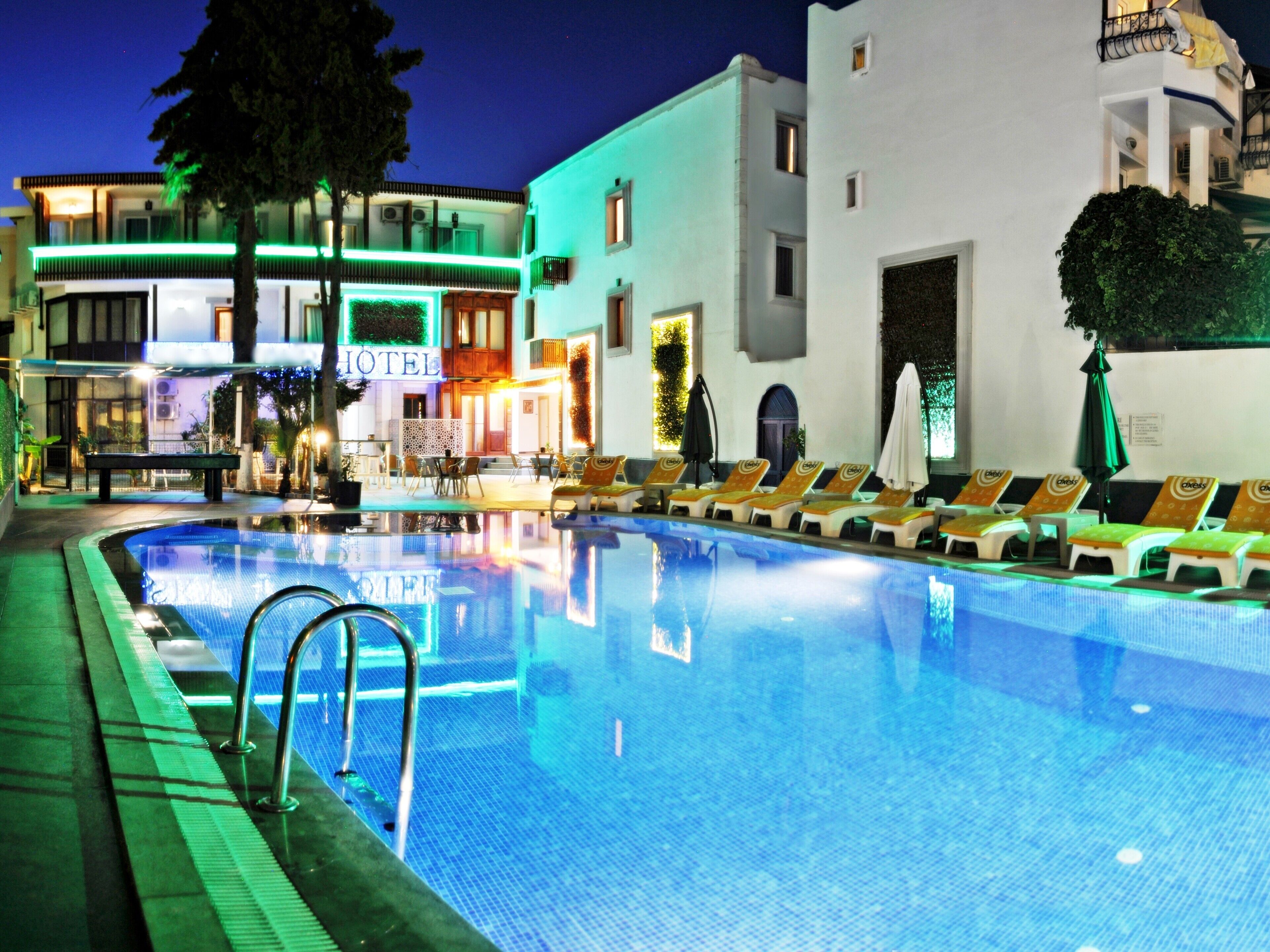 A hotel pool area with lounge chairs and a clear pool.
