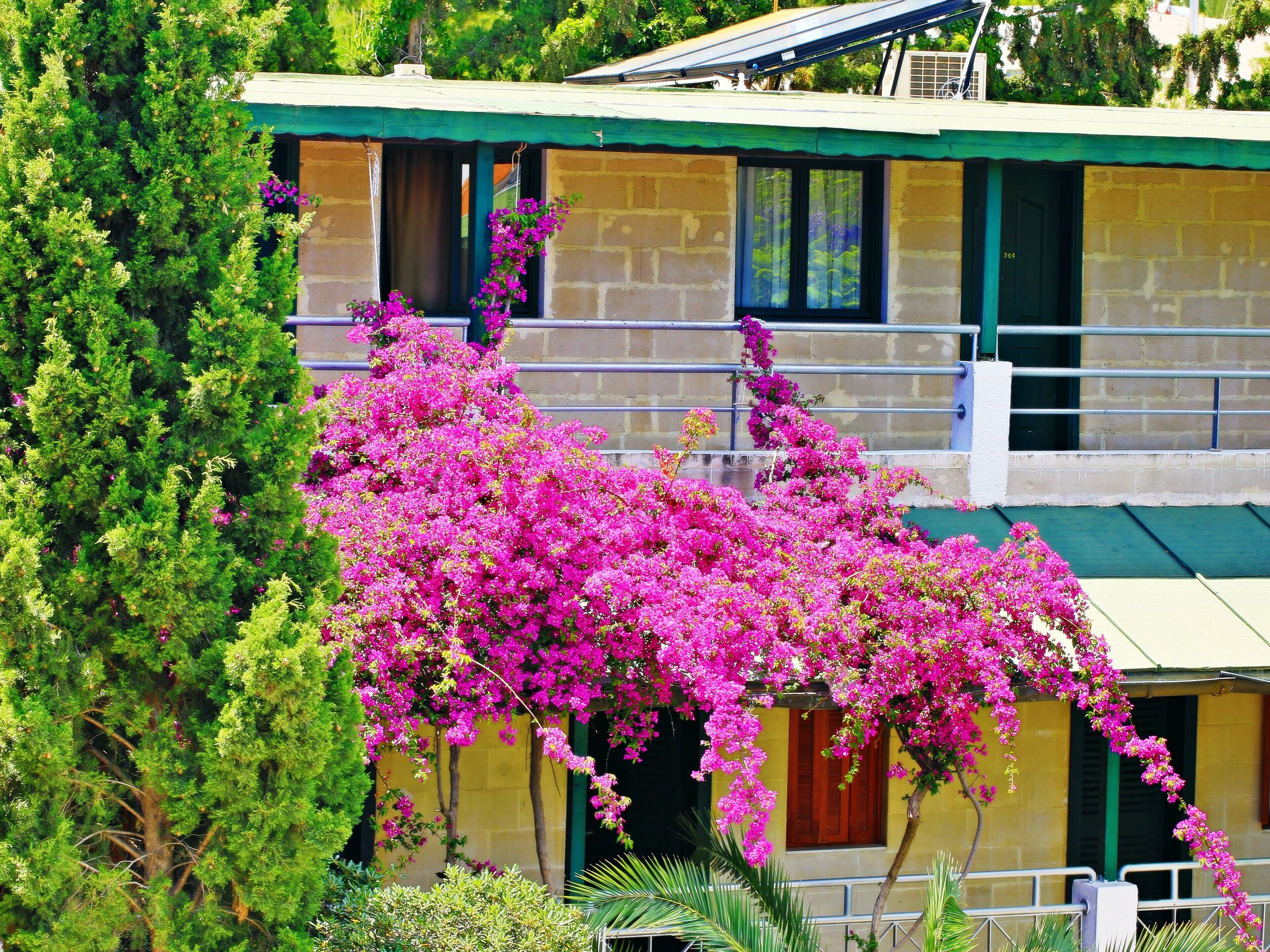 A building with a green roof and a balcony.
