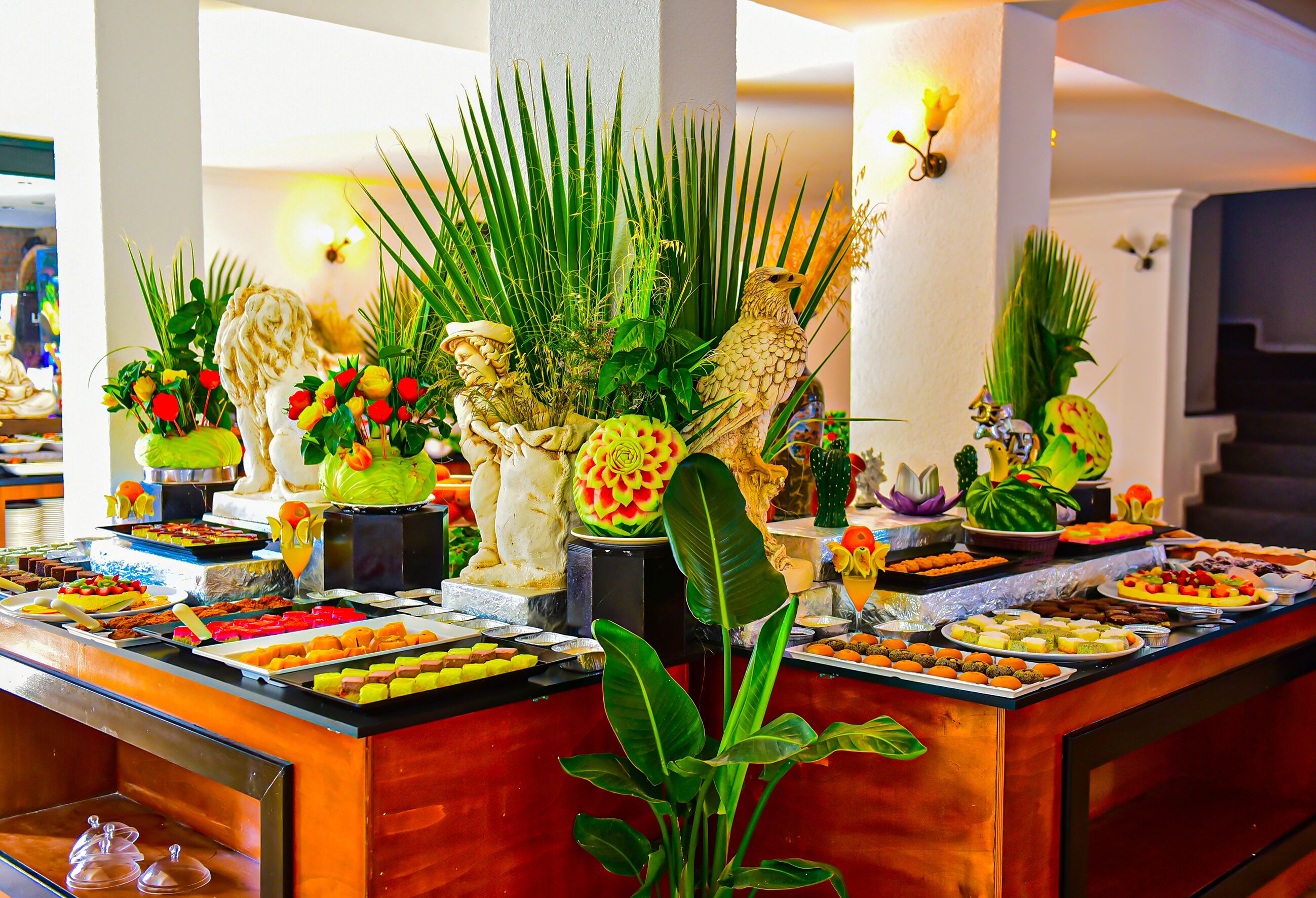 Een buffet met diverse gerechten en decoratieve planten.