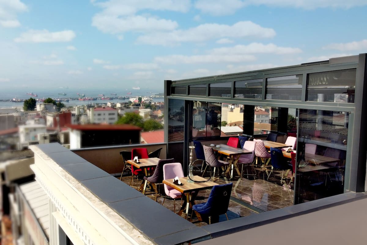 A rooftop terrace with a view of the sea and cityscape.