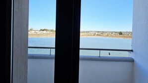 Ein Balkon mit Blick auf ruhiges Wasser und entfernte Küste.