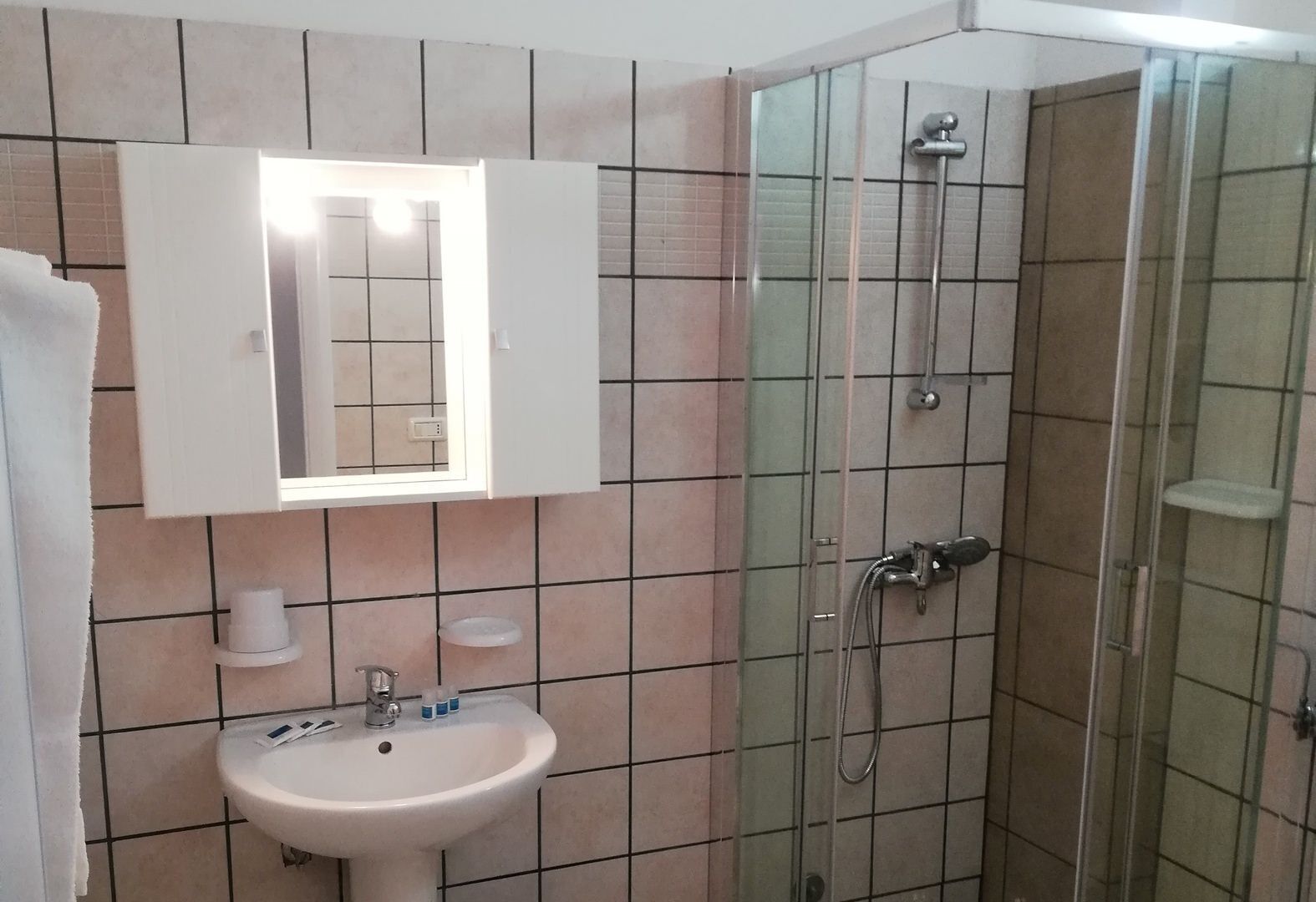 Ein Badezimmer mit Waschbecken, Spiegel und Dusche.