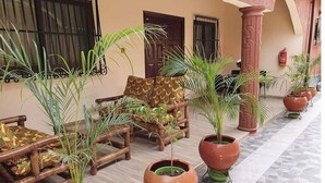 Un patio con mobiliario de madera y plantas en macetas.