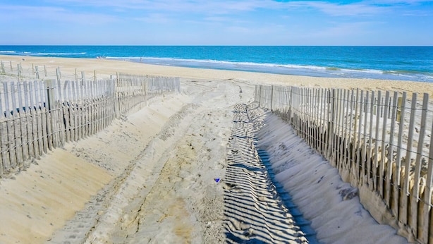 A beach with a wooden fence leading to the shore. - Enjoy the beautiful view of the Ocean from this one bedroom condo located in midtown! (Ocean City)