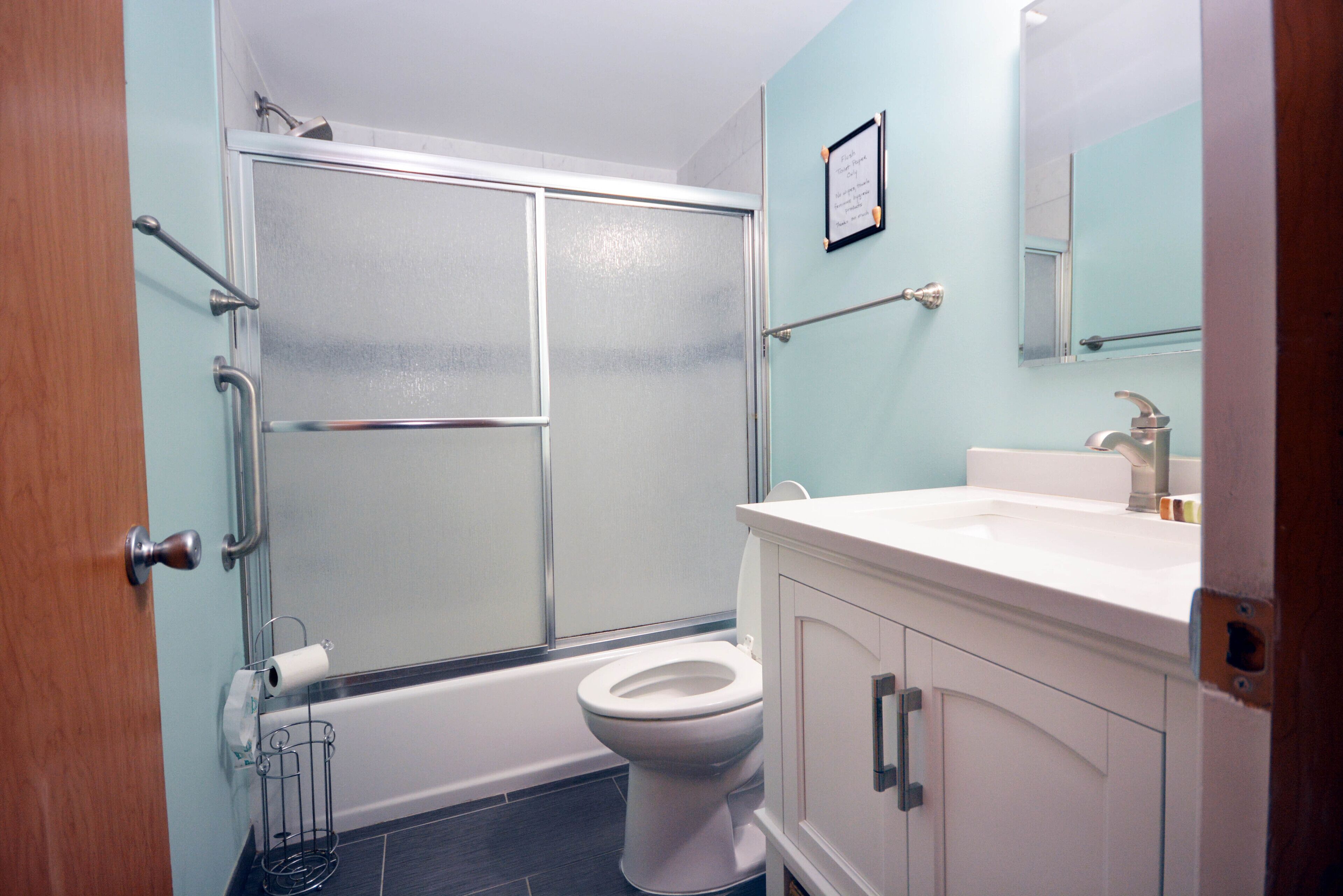A bathroom with a shower, toilet, and sink.