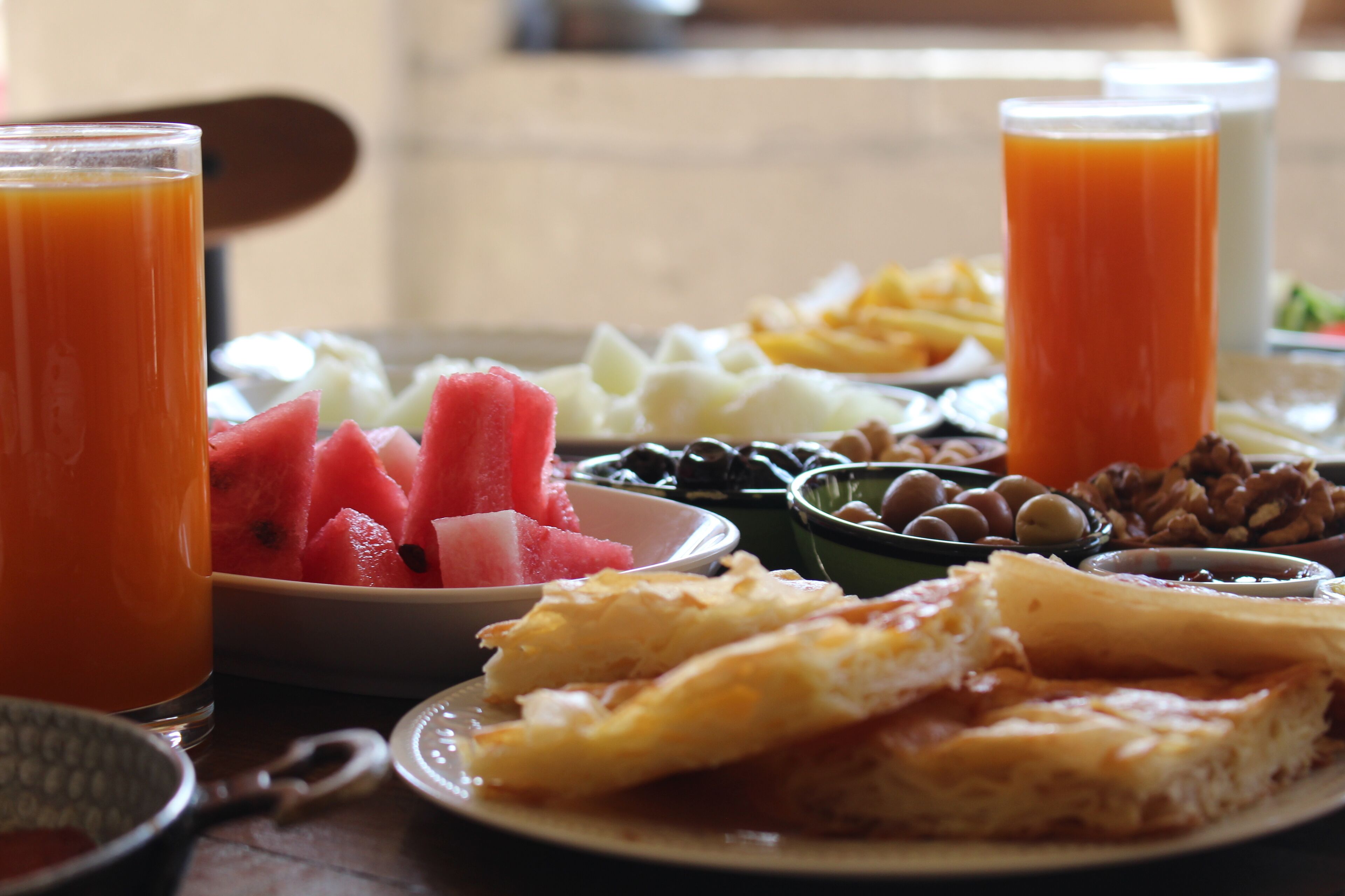 A breakfast table with various food items and drinks.