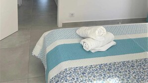 A hotel room with a bed, a TV mounted on the wall, and a view of the sea through an open door. - apartment 510A VORA 3 bedrooms (Calpe/Calp)