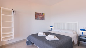 A hotel room with a bed, two bedside tables with lamps, a wall-mounted shelf, and a painting. - Apartment 510A VORA, 3 bedrooms (Calpe/Calp)