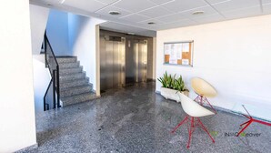 A modern interior with a staircase, elevators, a bulletin board, and a seating area with plants. - mizzen 84, 3 bedrooms (Calpe/Calp)