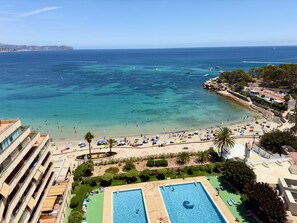 Un complexe hôtelier doté d’une piscine, d’une plage et offrant une vue sur l’océan.