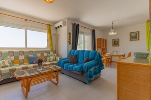Een woonkamer met een bank, een eettafel en een salontafel.