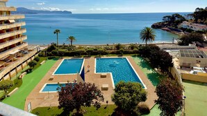 A hotel with a pool area, a view of the sea, and a mountainous backdrop. - apartment 46A VORA 2 bedroom (Calpe/Calp)