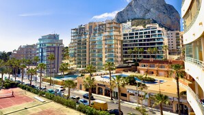 A coastal cityscape with modern high-rise buildings, a prominent rocky cliff, and a swimming pool area. - apartment 46A VORA 2 bedroom (Calpe/Calp)