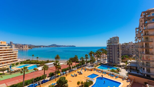 Ett semesterhotell med flera pooler, en strand och utsikt över havet.