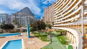 A hotel with multiple floors, a swimming pool, and a mountain in the background. - 21C VORA 1 bedroom with sea views and wifi (Calpe/Calp)