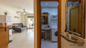 A compact living space with a kitchenette, a dining area, and a laundry area. - 112 Calpeplace with large terrace, wifi and pool (Calpe/Calp)