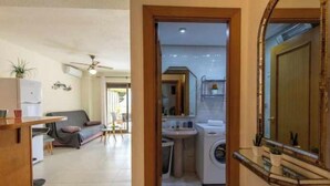A compact living space with a kitchenette, a dining area, and a laundry area. - 112 Calpeplace with large terrace, wifi and pool (Calpe/Calp)