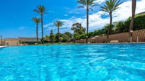 A clear blue swimming pool with palm trees and a brick wall in the background. - 112 Calpeplace with large terrace, wifi and pool (Calpe/Calp)