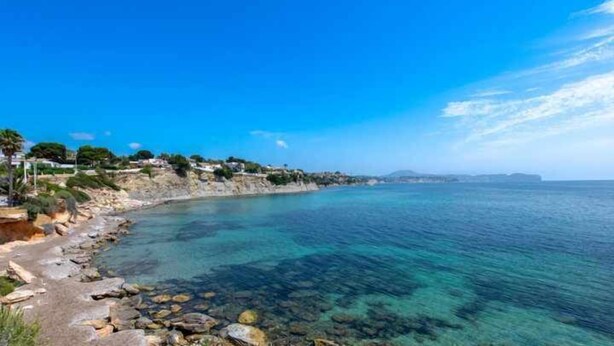 A coastal landscape with clear blue waters, rocky shore, and buildings on the hillside. - 112 Calpeplace with large terrace, wifi and pool (Calpe/Calp)