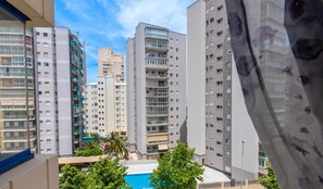 A high-rise residential building with multiple balconies, a swimming pool, and a view of other buildings. - 13D TB 2 bedrooms, 2nd line beach with sea views (Calpe/Calp)