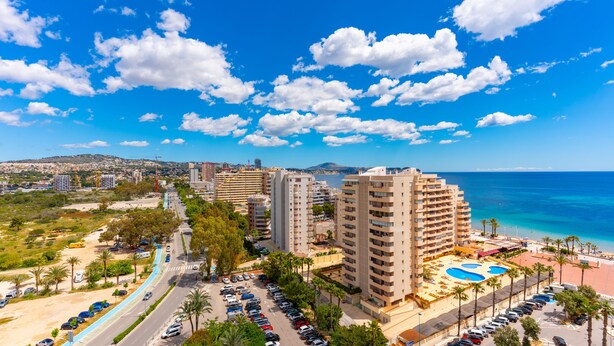 A coastal hotel with multiple high-rise buildings, a swimming pool, and a road with parked cars. - Apollo17 E39, 2 bedrooms (Calpe/Calp)