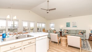 A spacious living area with a kitchen, dining space, and a balcony with a view.