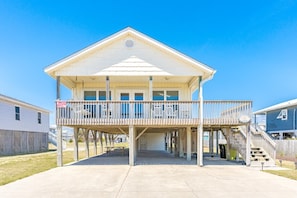 A two-story house with a balcony, a covered porch, and a staircase leading to the upper floor.