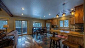 A spacious kitchen with wooden cabinets, a central island, and a dining area with a bench and chairs.