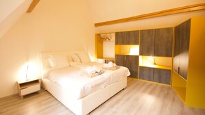 A bedroom with a bed, bedside table, wardrobe, and a lamp. - Le Ch'ti Alsacien ***, duplex apartment for 4/6 people in the heart of Eguisheim (Eguisheim)