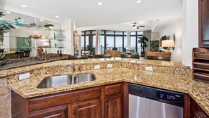 Una cocina con encimeras de granito, electrodomésticos de acero inoxidable y armarios de madera.